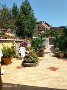 a patio with a white chair and some plants at Casa vacanze Antonella in Oristano