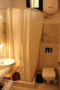 a bathroom with a white shower curtain and a toilet at Elia Studio in Platamonas