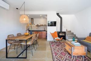 a dining room and living room with a table and chairs at Casa da Aguda in Colares