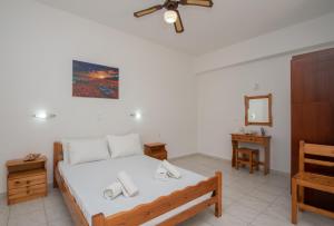 Schlafzimmer mit einem Bett, einer Kommode und einem Spiegel in der Unterkunft Golden sand Paradise II in Planos