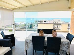 a dining room with a table and chairs and a balcony at Samaya Sea view in Civitavecchia