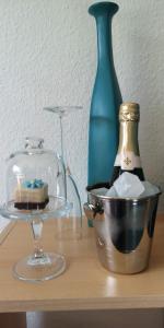 una mesa con un tazón de cristal y una botella de vino en Ninas B&B - exklusiv für Frauen en Bremen