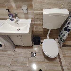 uma casa de banho com um WC branco e um lavatório. em Real Apartments em Budva