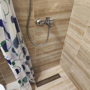 a shower with a shower head and a shower curtain at Real Apartments in Budva