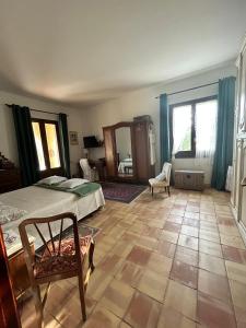 a bedroom with a bed and a chair and a mirror at La finestra sul limone in Castelvetrano Selinunte