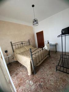 ein Schlafzimmer mit einem Bett, 2 Tischen und einem TV in der Unterkunft Domus Petra in Rocca Cilento