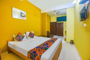 a bedroom with a bed in a yellow room at FabExpress Casa Paradiso, Panaji in Goa