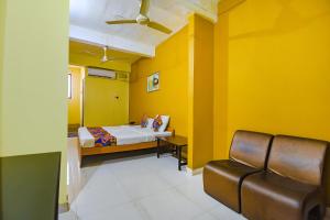 a yellow room with a bed and a chair at FabExpress Casa Paradiso, Panaji in Goa