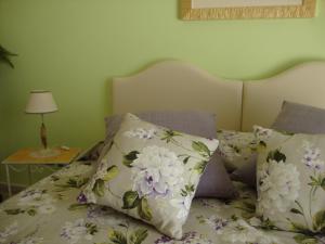a bedroom with a bed with floral pillows at Sunny Holidays Casa Vacanze in Meta