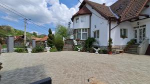 a white house with a brick driveway in front of it at Vila Daiana- Acceptam vouchere vacanta in Moieciu de Jos