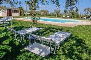 two picnic tables in front of a swimming pool at Villa Ada in Rosolini