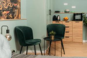 twee groene stoelen en een tafel in een kamer bij Brandnew Designed Citycenter Apartment in Boedapest