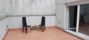 two chairs and a flower pot on a balcony at CaLi Apart Center in Lugo
