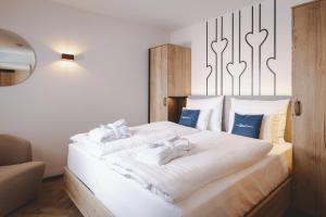 a bedroom with two beds with white sheets at The Gast House Zell am See in Zell am See