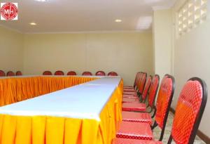 uma sala de conferências com uma mesa longa e cadeiras vermelhas em Machakos Inn Hotel em Machakos