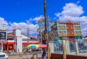 un grupo de edificios con una valla y una sombrilla en Machakos Inn Hotel, en Machakos