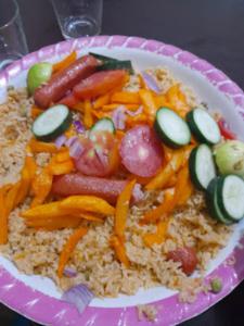 a plate of food with sausage vegetables and rice at Machakos Inn Hotel in Machakos