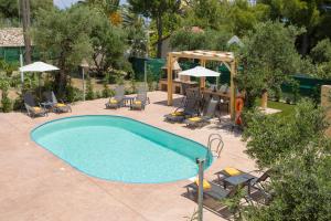 una piscina con sillas, una mesa y sombrillas en Villa Melody Complex en Akrotiri