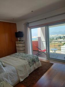 a bedroom with a bed and a large window at Vila Cantinho Algarvio Vista Rio in Ferragudo