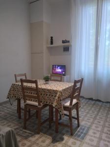 a dining room with a table and chairs and a television at APPARTAMENTO CENTRO-LAME in Bologna