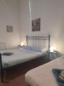 a bedroom with two beds and two tables with lamps at APPARTAMENTO CENTRO-LAME in Bologna