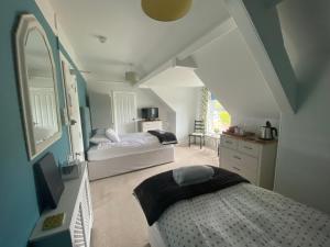 a bedroom with a bed and a mirror in a room at Camelot Guest House in Falmouth
