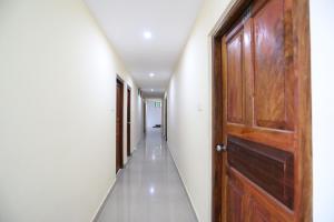 an empty corridor with a wooden door and a hallway with a hallway at OYO Flagship Jazeera Resort in Haddo