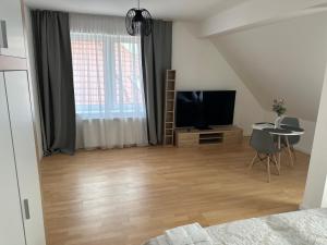 布拉格的住宿－Rezidence Kbely，一间带电视和桌子的客厅