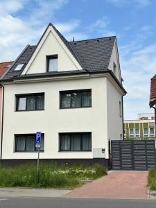 布拉格的住宿－Rezidence Kbely，前面有蓝色停车标志的白色房子