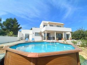 Villa con piscina frente a una casa en Modern Villa in Cala Jondal Porroig, en Sant Josep de sa Talaia