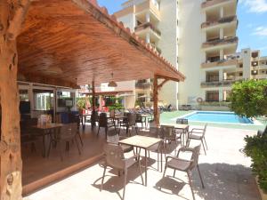 a patio with tables and chairs next to a pool at Apartamentos Arlanza - Only Adults in Playa d'en Bossa