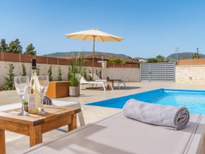 patio con tavolo, bicchieri da vino e piscina di Villa Aqua - Laganas Stone Villas a Laganas