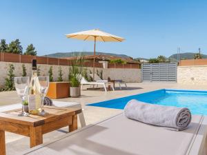 a patio with a table with wine glasses and a pool at Villa Aqua - Laganas Stone Villas in Laganas