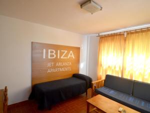 una sala de estar con sofá y un cartel en la pared en Apartamentos Arlanza - Only Adults, en Playa d'en Bossa