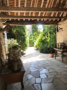 un patio al aire libre con suelo de piedra y techo de madera en Le 7 du Clos Fleuri, 