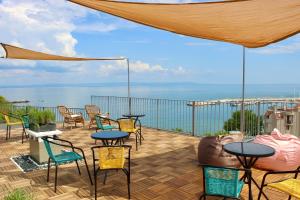 eine Terrasse mit Tischen und Stühlen und Meerblick in der Unterkunft SUNSET ART Beach Front in Tschernomorez