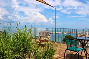 eine Terrasse mit 2 Stühlen und einem Tisch auf dem Balkon in der Unterkunft SUNSET ART Beach Front in Tschernomorez