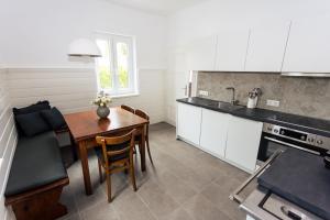 a kitchen with a table and a dining room at Haus Roserlheim in Pörtschach am Wörthersee +15 photos