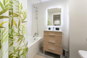 y baño con bañera, lavabo y espejo. en CT 245 - Faro's Arroyo de la Miel Apartment - Cuddly Nest for 2, en Arroyo de la Miel