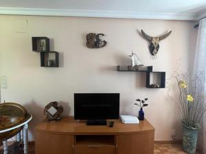 Apartamento Toki Berriya في إليزوندو: غرفة معيشة مع تلفزيون على طاولة خشبية