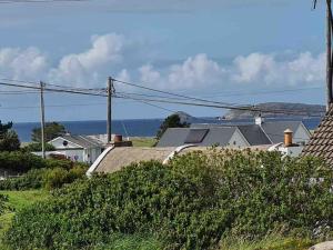 ein Dorf mit Häusern und dem Meer im Hintergrund in der Unterkunft Mickey's House in Annagry