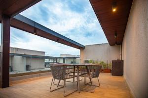 d'une terrasse avec une table et des chaises sur un balcon. dans l'établissement Villa Amara 29 by Stay ALYF, Lonavala, à Lonavala