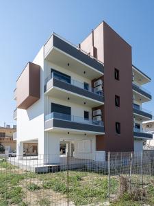 an apartment building with a fence in front of it at Mossa City Apartments in Chania Town