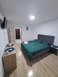 1 dormitorio con 1 cama grande y 1 mesa en Garsoniera Luxury Lorena, en Piteşti
