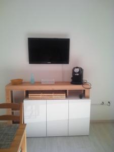 un centro di intrattenimento con un televisore sopra di CASA VACANZA YDROUS a Otranto