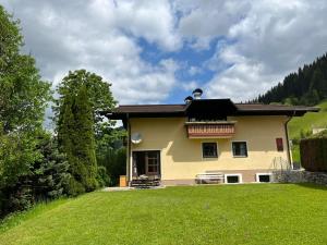 una gran casa amarilla con césped verde en Kesselgrubs Wohlfühlappartements, en Eben im Pongau