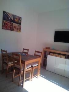 uma sala de jantar com uma mesa e cadeiras e uma televisão em CASA VACANZA YDROUS em Otranto