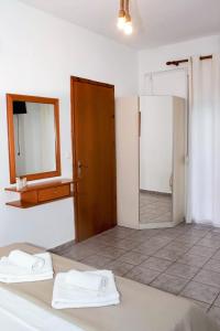 a bathroom with two towels on a bed with a mirror at Starry Coast Apartments in Nea Potidaea