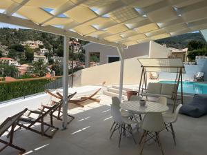 a patio with a table and chairs and a pool at Vassilis Retreat in Asos