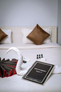 a book and a white snake on a bed at GS RESIDENCY in Guwahati
